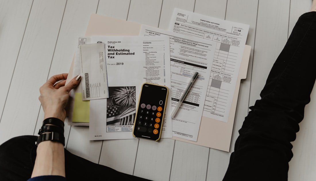 Calculatrice posée sur des documents financiers — estimer le budget du référencement SEO et GEO au Maroc